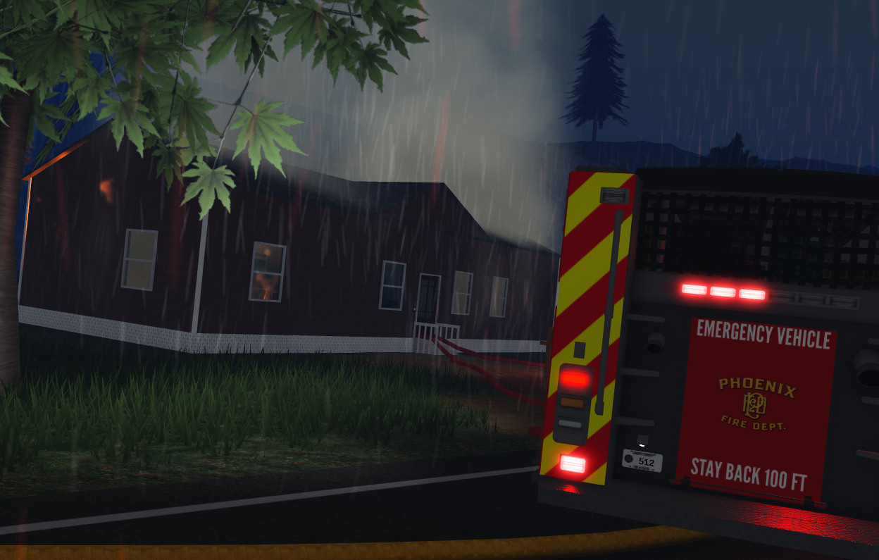 Rear of a Phoenix fire engine beside a house fire in the rain.